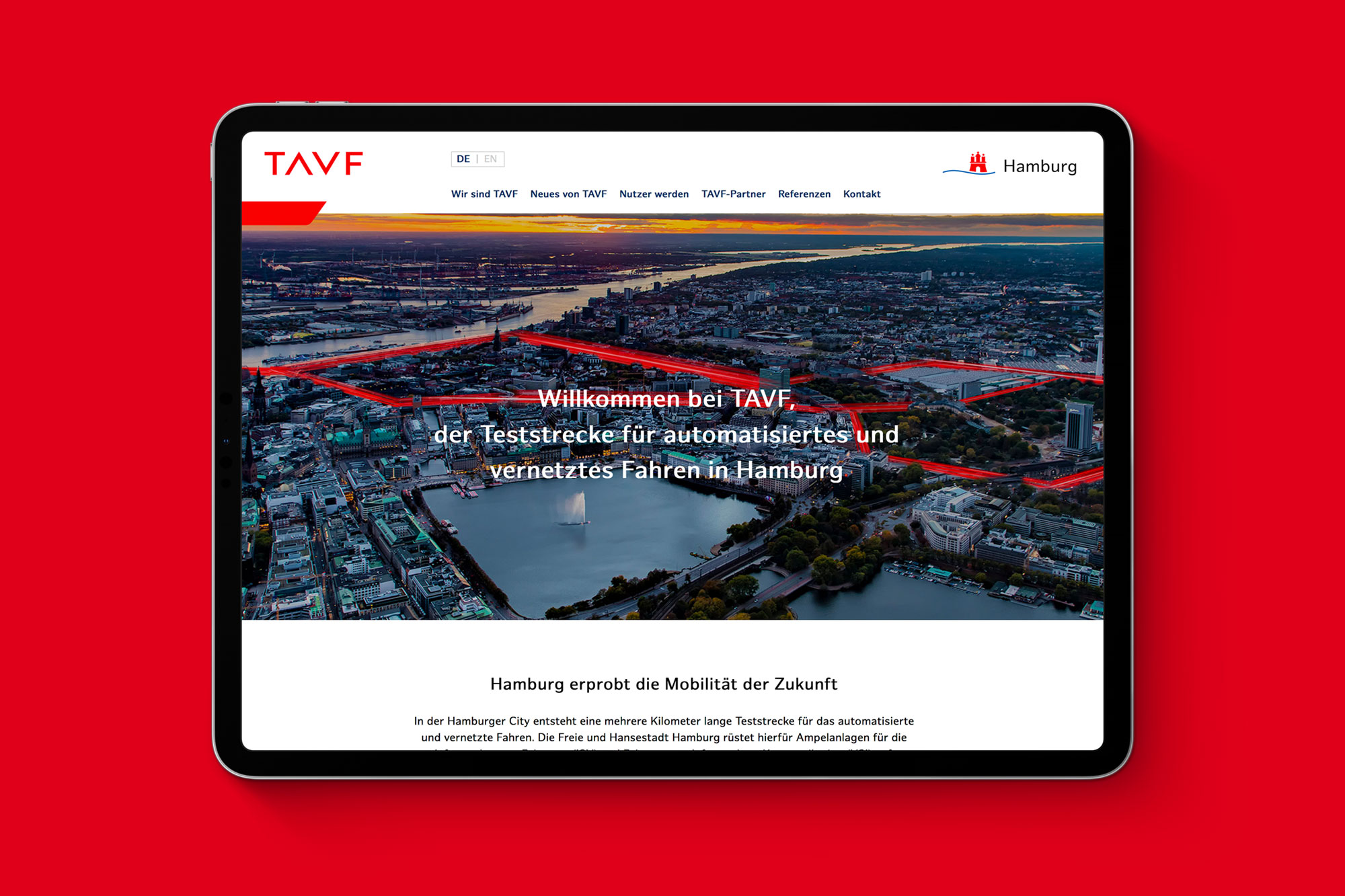 iPad auf rotem Hintergrund zeigt die Website für TAVF – die Teststrecke für automatisiertes und vernetztes Fahren in Hamburg